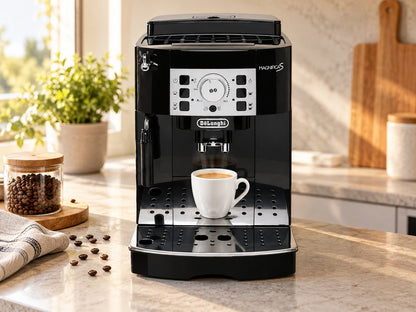 De'Longhi Magnifica S ECAM 22.110.B avec une tasse d’expresso sur un plan de travail, à côté de grains de café